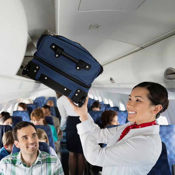 Passenger holding a blue suitcase above their head in an airplane cabin.